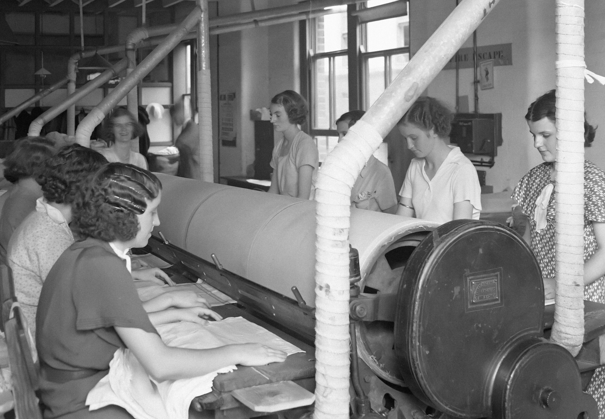 a group of women working on a machine in a factory